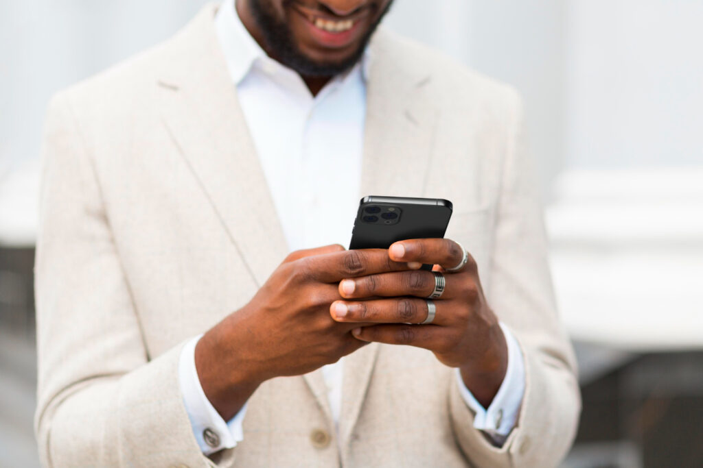 Close up of man holding mobile phone and smiling